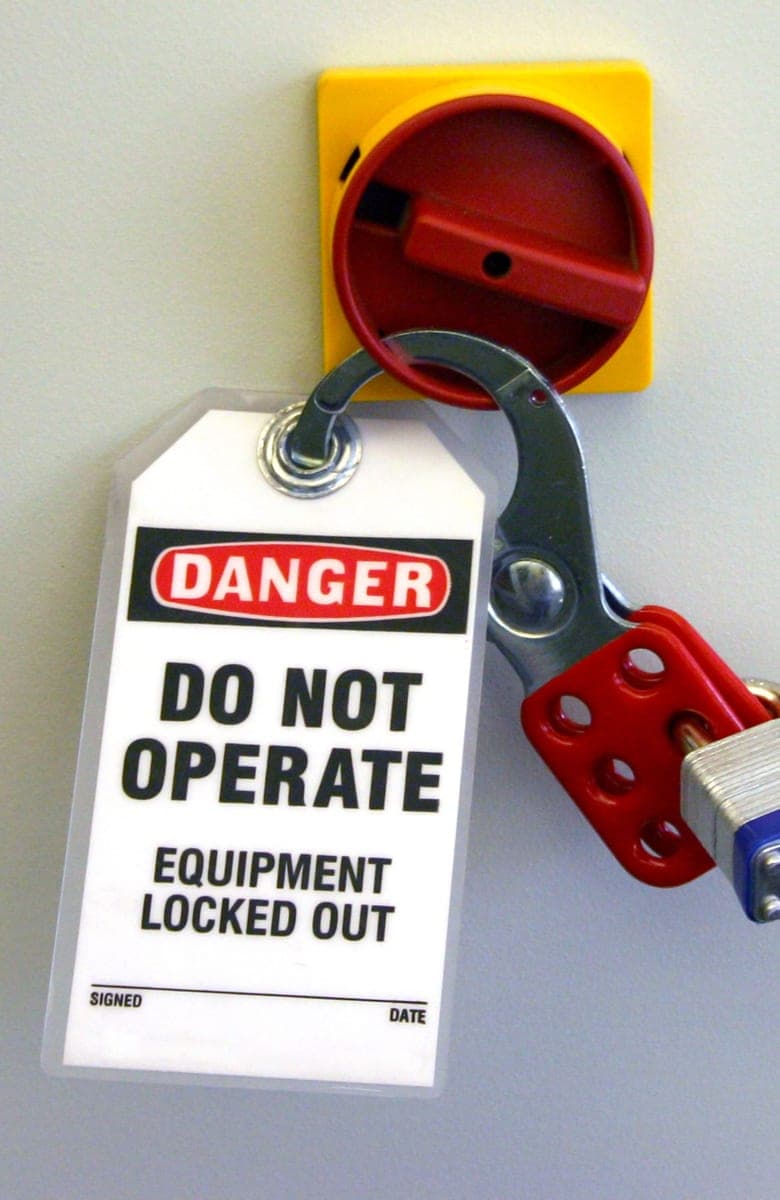 Lockout/tagout tag reading Danger, Do Not Operate, Equipment Locked Out, padlocked to an electrical disconnect switch