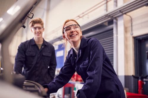 Technician spray painting car with GMG's EHS-compliant collision repair solutions