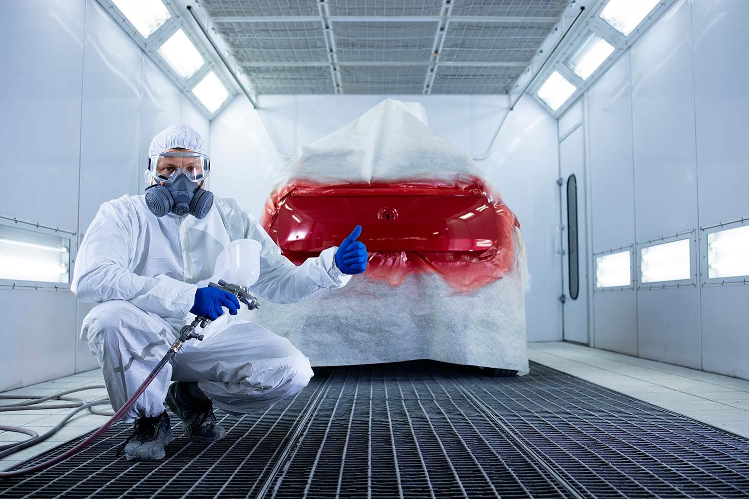 Worker applying a spray coating in an industrial workshop