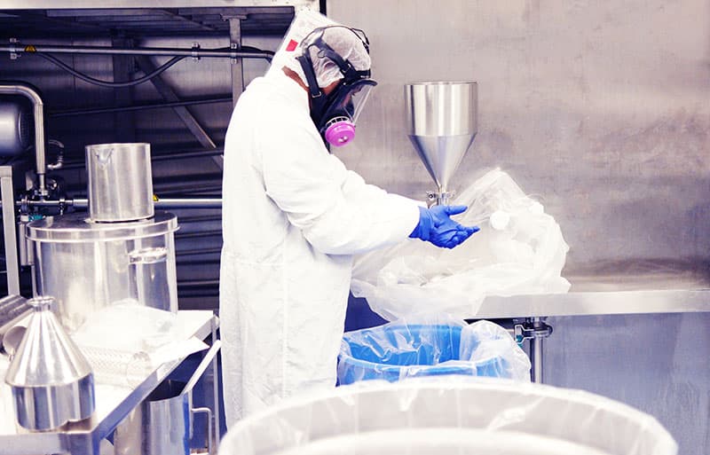 Worker handling coatings and solvents in an industrial facility
